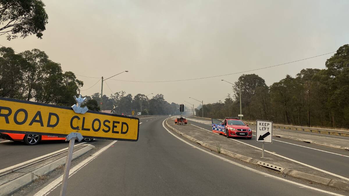 Smoke rises from the Comberton fire in the background of a road closure on the Princes Highway. Picture: Stuart Thomson.