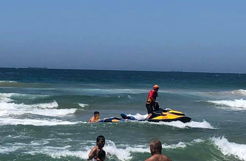 A swimmer is helped to shore during a mass rescue at Bulli on Sunday. Picture: Surf Life Saving Illawarra 