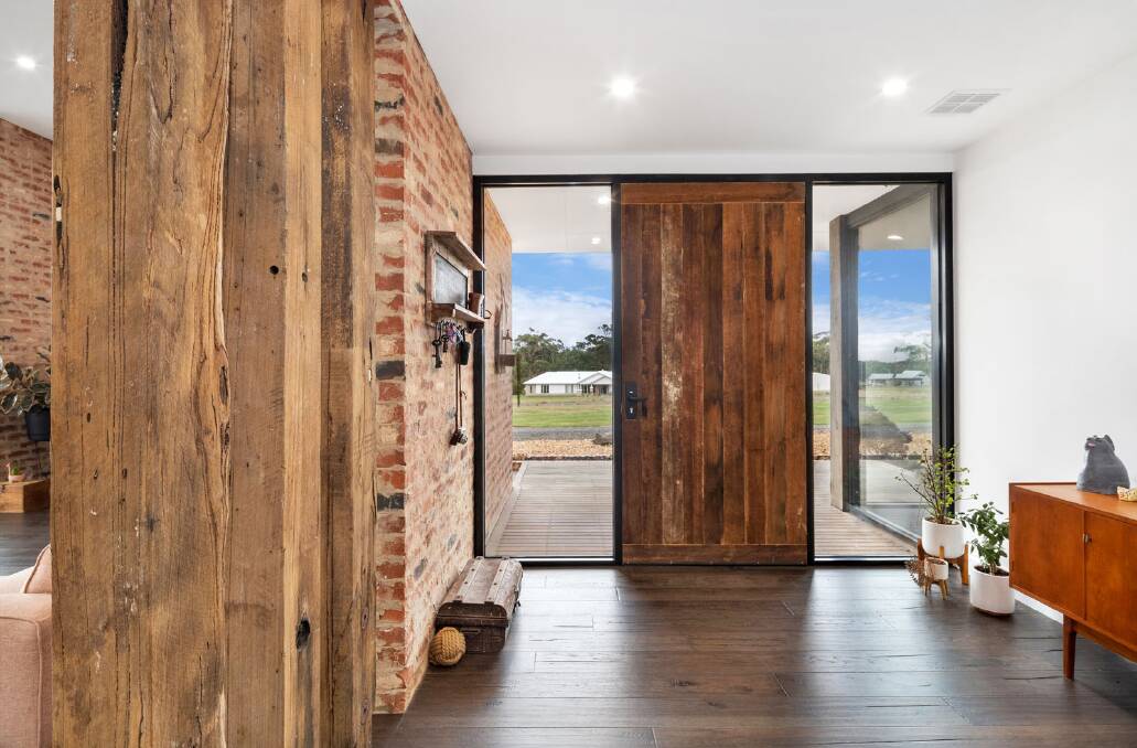The foyer immediately shows the connection between outer and inner materials with the reclaimed timber and recycled bricks adding warmth and colour.