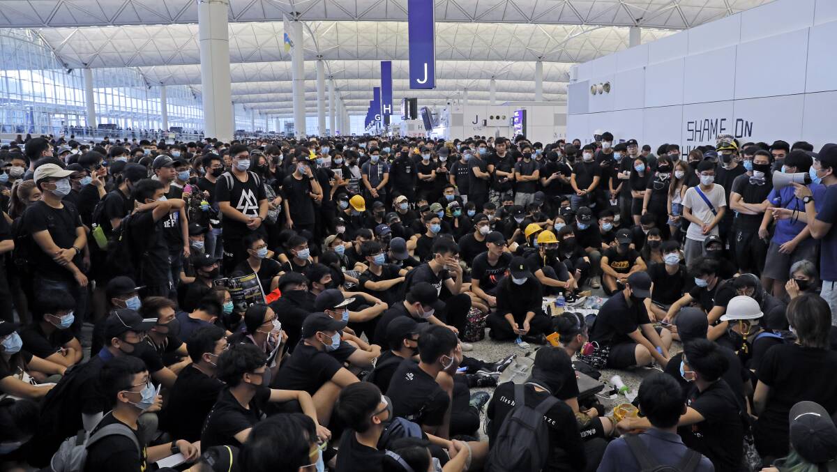 Protesters gather near an information board during a protest at the Hong Kong International Airport on Monday, August 12. Picture: AP