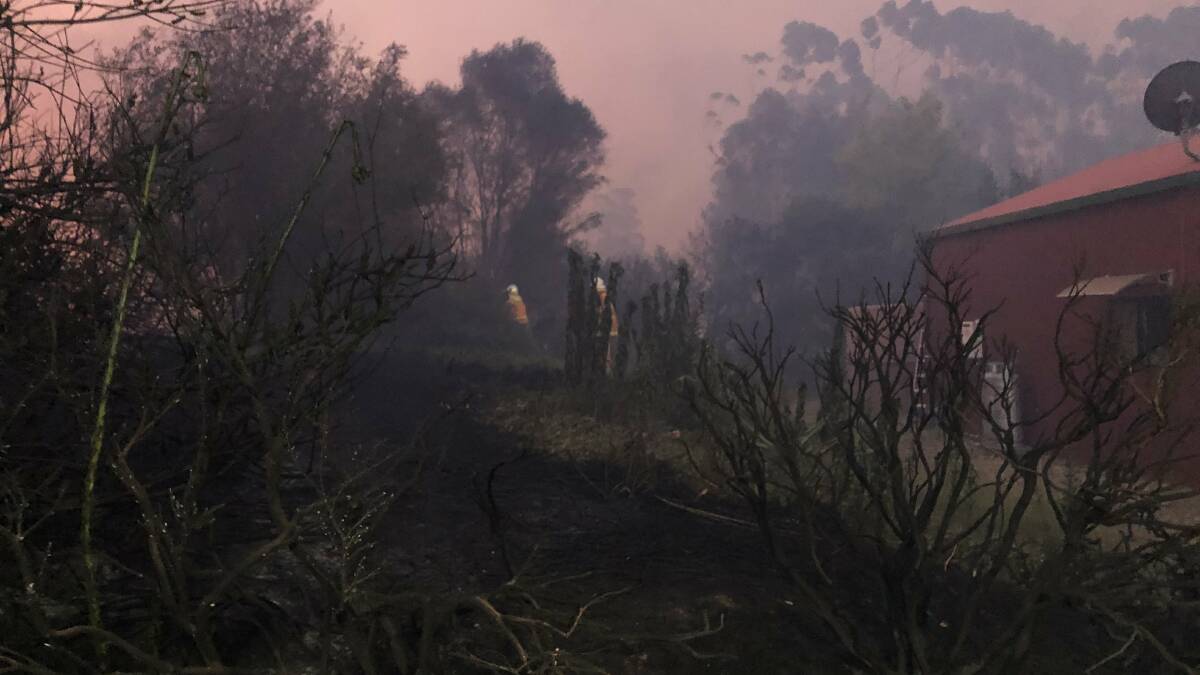 Fire crews work to protect homes from an out of control bushfire burning on the South Coast. Picture: NSW Rural Fire Service