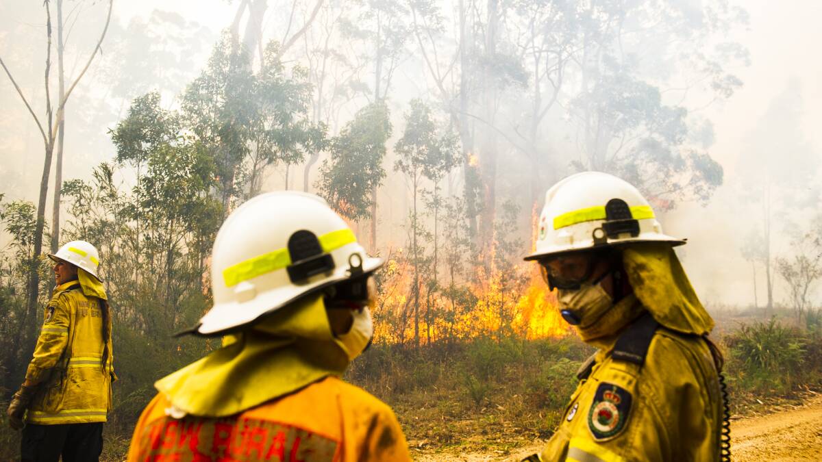 NSW Rural Fire Service firefighters protect a property from the Currowan fire in December. The Clyde Mountain fire formed on the southern end of the Currowan blaze. Picture: Dion Georgopoulos