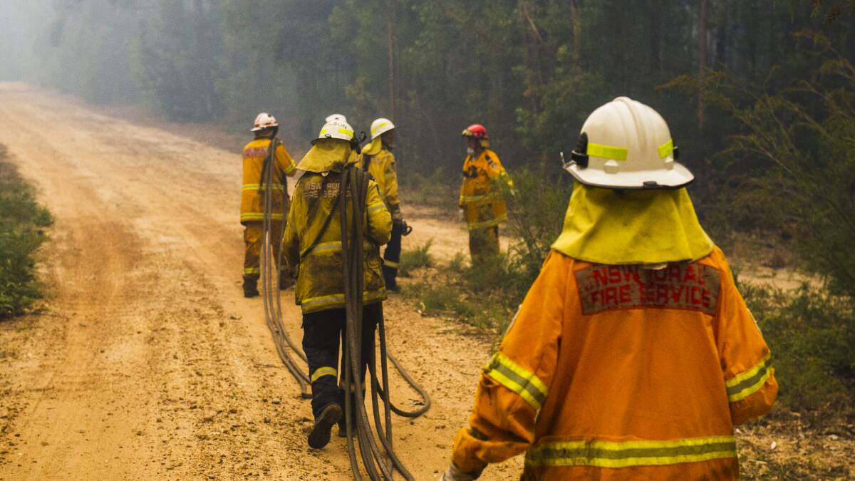 NSW Rural Fire Service firefighters come to protect a property on Tallow Wood Rd from the Currowan Fire. Picture: Dion Georgopoulos