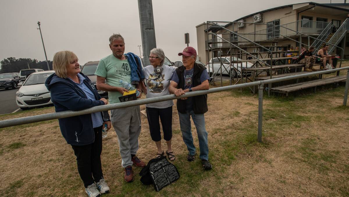 From left: Heather and Julian Hubble of Rosedale and Lilli and Ian Blatch keep each others' spirits up at the Batemans Bay evacuation centre during the fires. Picture: Karleen Minney