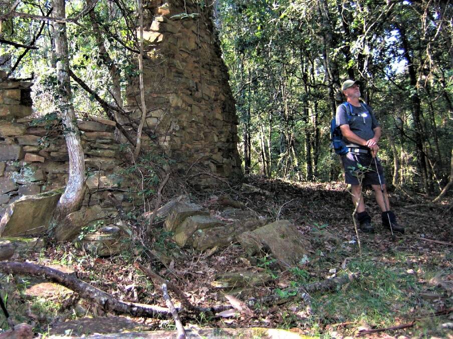 Back in time: Tony Garten reflects on the life of Black Flat Billy at the remains of his old stone hut during the bushwalk near Nelligen.