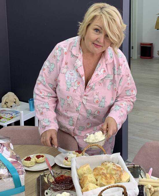 Fashionista: Christine Ewin was looking "pretty in pink" as she helped herself to
a prize-winning scone at her PJ day to raise funds for kids in need.