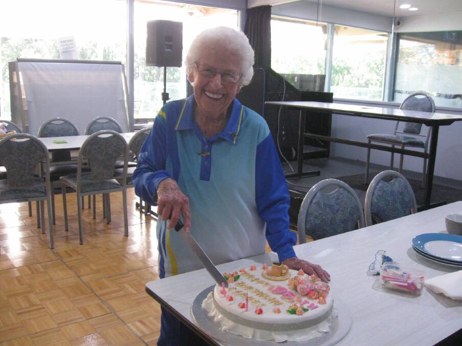 Carmel Elliott cutting her 95th birthday cake.