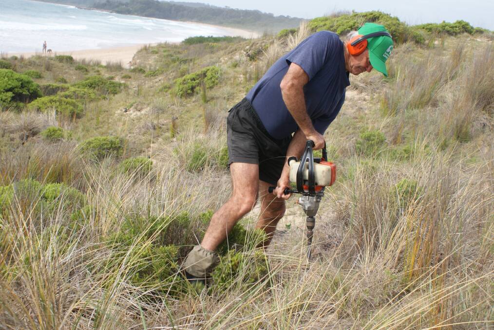 Important work: South Durras Landcare group won the community involvement award at the NSW Coastal Management Awards last week. Pictured is South Durras Landcare's Paul May preparing plant holes.