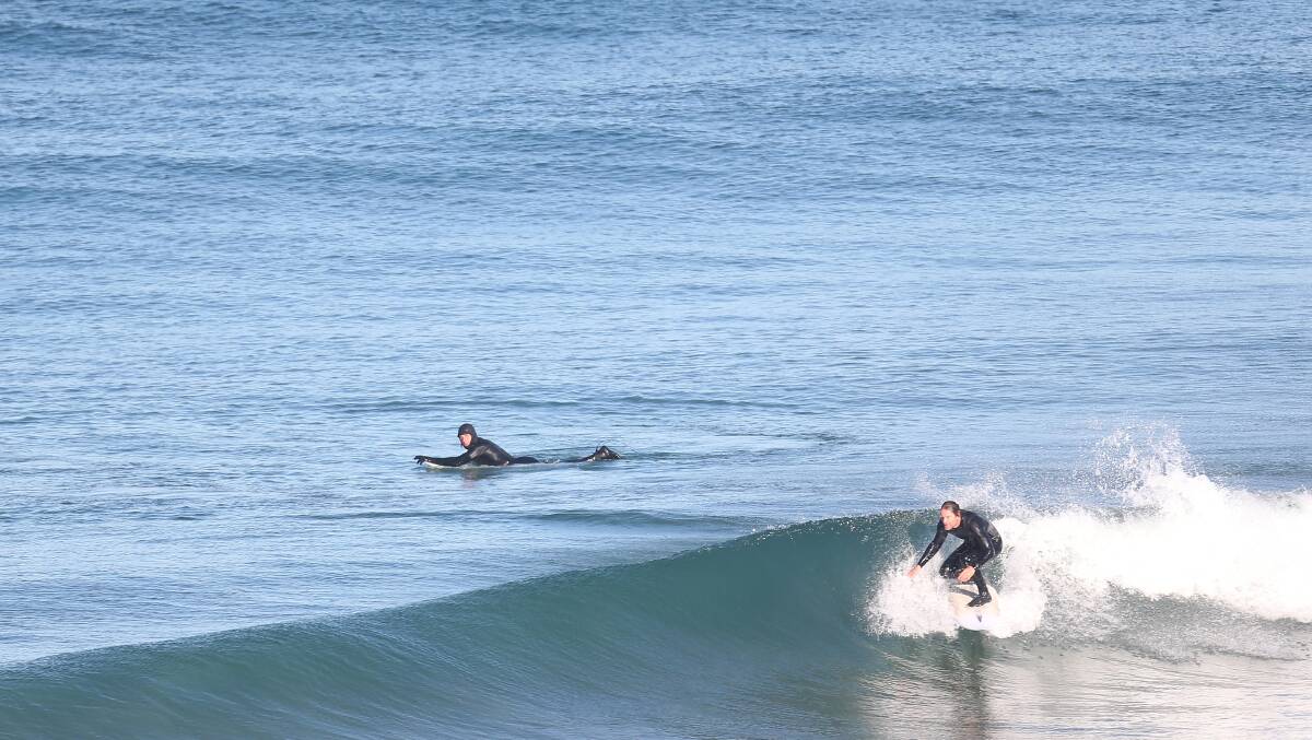 Surfers at Logan's Beach. Picture: Mark Witte