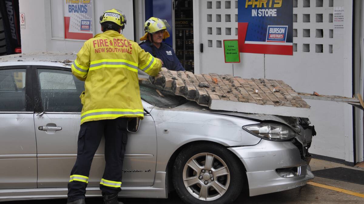 Batemans Bay Fire and Rescue help tow a car out of a shopfront window where it crashed on March 29.