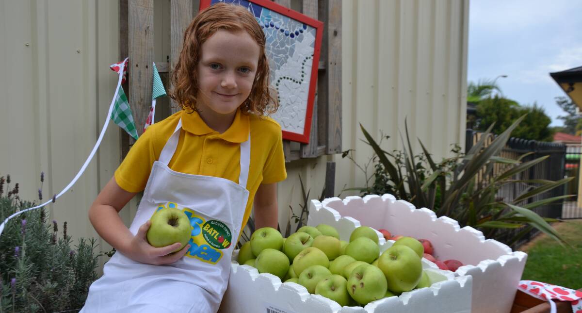 Year 2 student Mikayla Wade helps pack apples for school families.