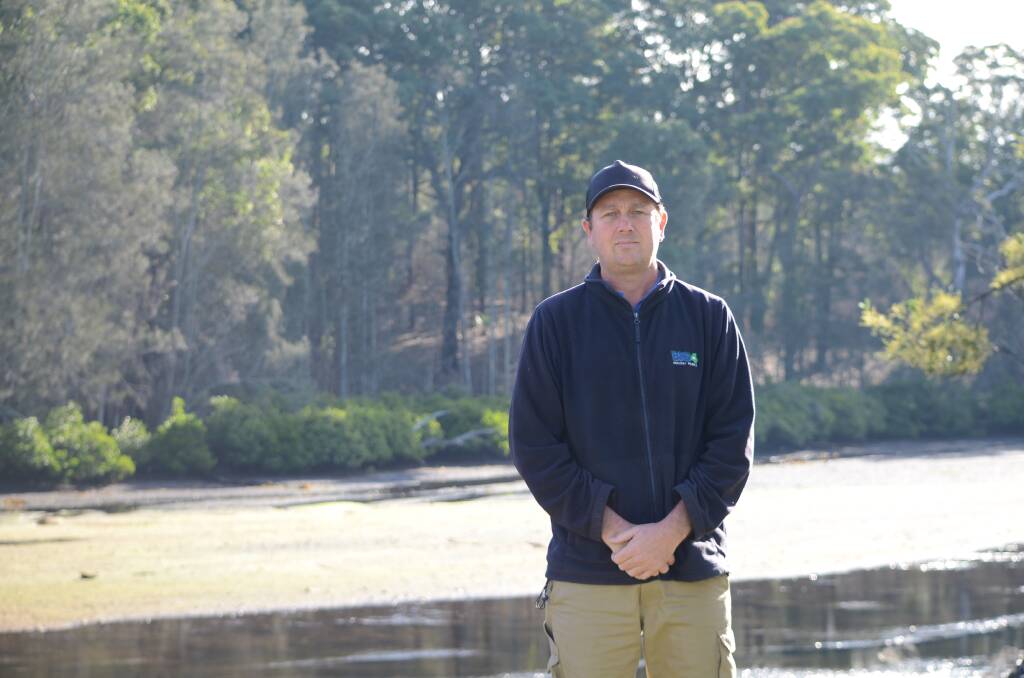 LOOKING AHEAD: Big4 Nelligen Holiday Park manager Tod Sutherland stands by Nelligen Creek at low tide in June. In February, the creek was at king tide, visitors were evacuated and the site was flooded. 