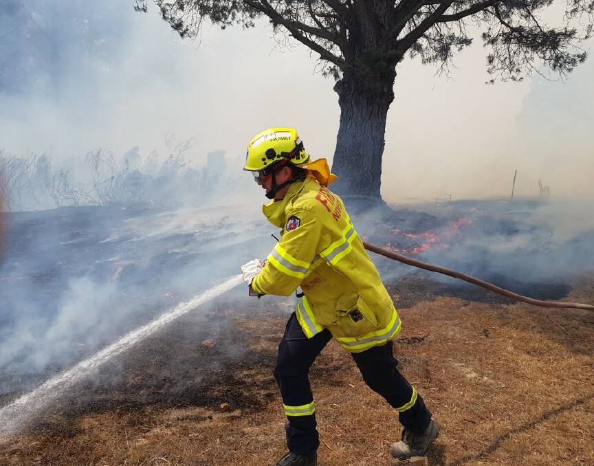 A Fire and Rescue firefighter in action battling a South Coast blaze. Fire and Rescue teams have been assisting RFS with fires at Currowan and Braidwood. Photo: Nowra Fire and Rescue 