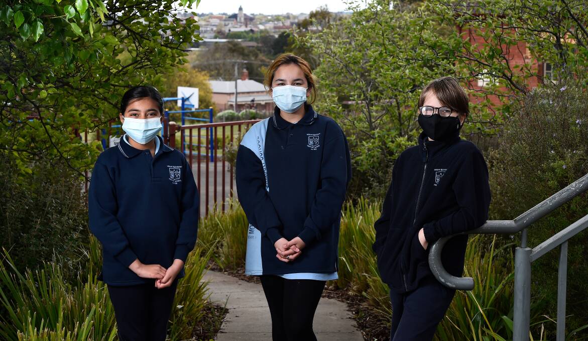 MASKED UP: Mount Pleasant pupils Kamal, Amelie and Cash wear masks at school. Picture: Adam Trafford