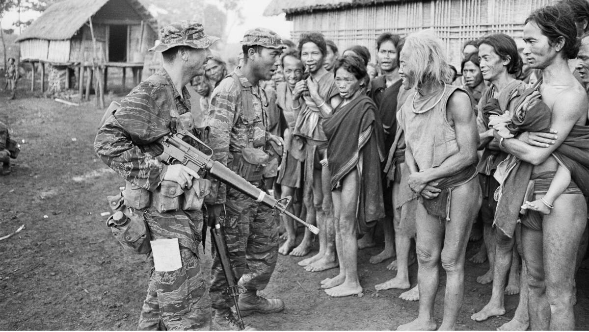 Captain Peter Shilston and South Vietnamese colleague Captain Ngac question a 'Montagnard' chief near Pleiku. Picture: John Fairley, courtesy AWM FAI/70/0590/VN.