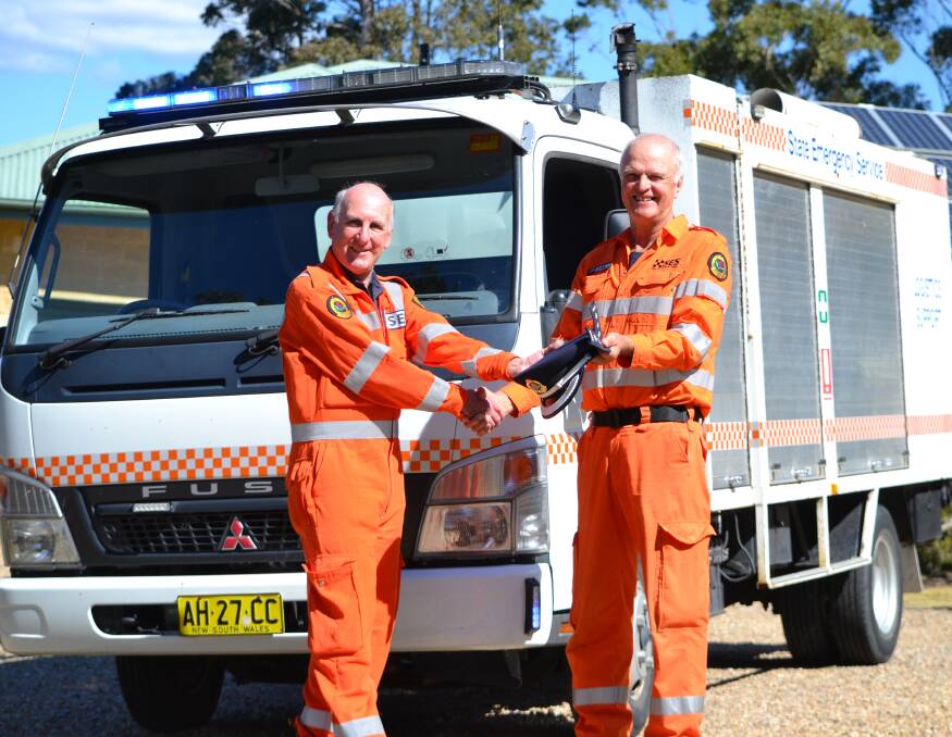 NEW ADVENTURE: Outgoing Moruya SES unit controller Jeff McMahon (right) officially hands over to Chris Zammit in Mossy Point on Saturday.