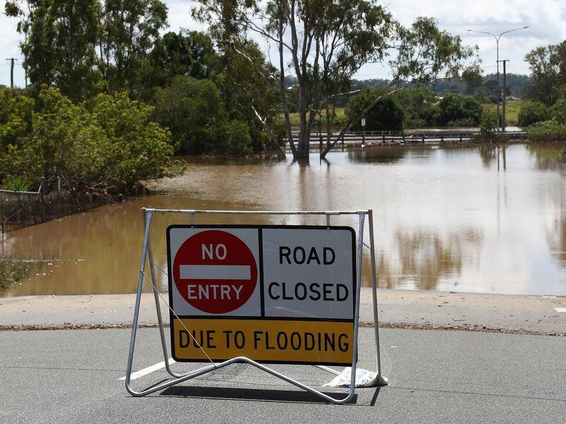 A woman has died after the car she was in became submerged in floodwaters in north Queensland.