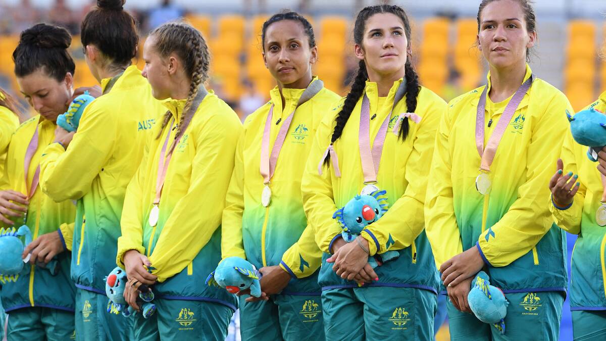 SHATTERED: Cassie Staples (centre) with her silver medal after Australia's heart-breaking 17-12 loss to New Zealand in the women's sevens final at the Commonwealth Games in April. Photo: Dave Hunt.