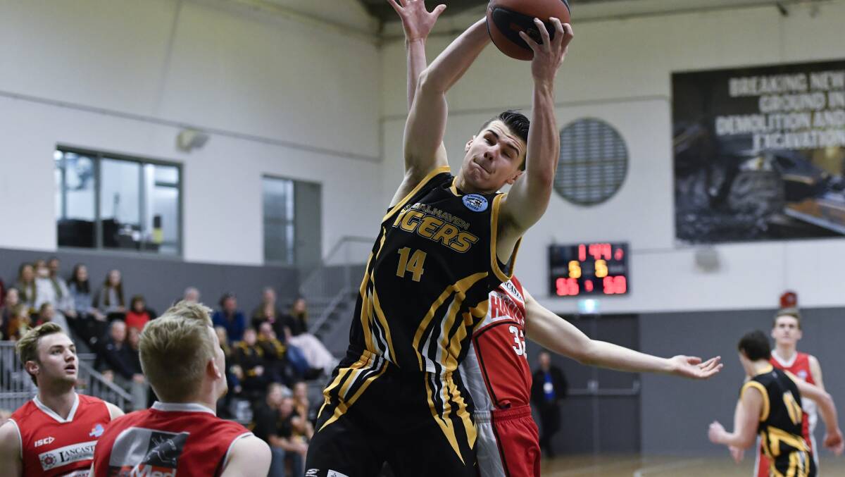 Riley O'Shannessy grabs a rebound during the Shoalhaven Tigers' win over the Illawarra Hawks. Photo: Basketball NSW Media.